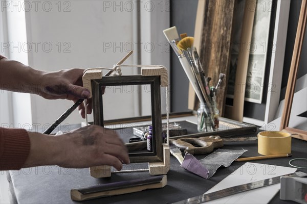 Hands of Caucasian artist making picture frame