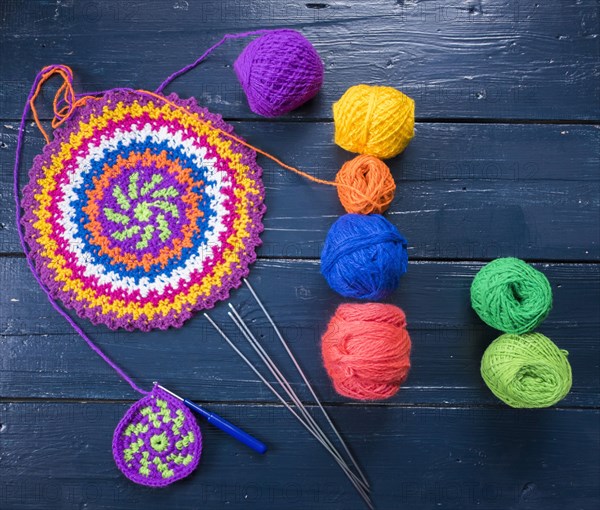 Knitting needles and multicolor yarn on blue table