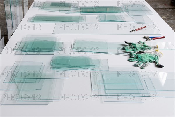 Piles of glass and glass cutter on white table