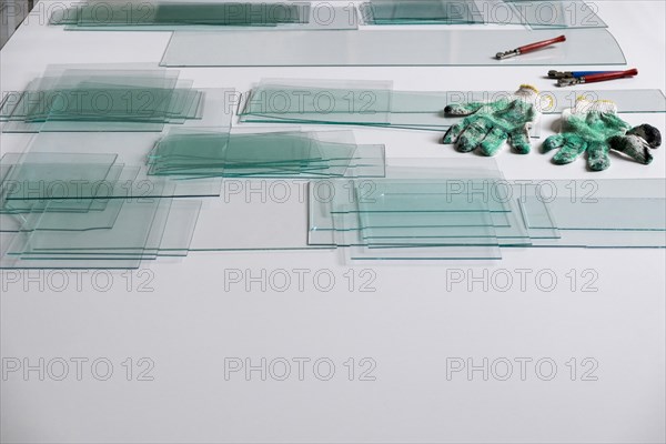 Piles of glass and glass cutter on white table