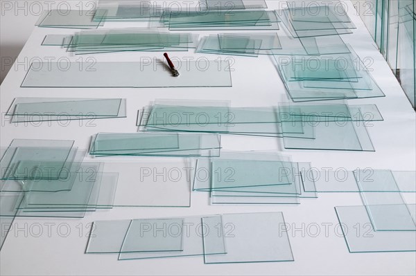 Piles of glass and glass cutter on white table