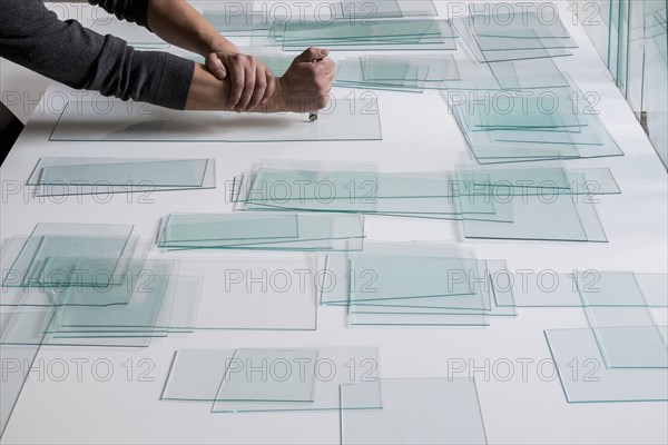 Piles of glass and glass cutter on white table