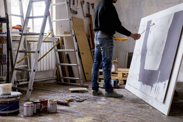 Caucasian artist painting with paint roller