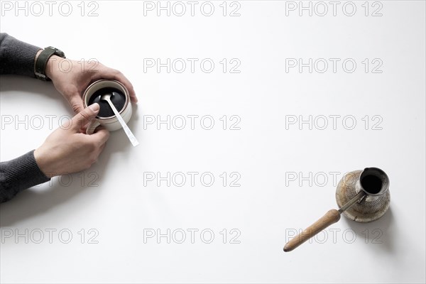 Hands of Caucasian man holding coffee cup