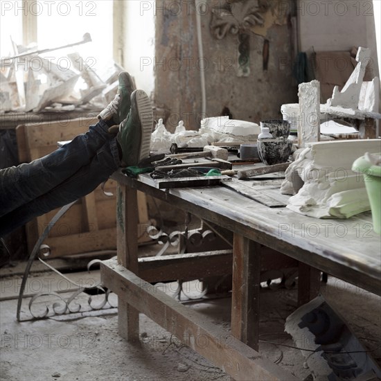 Caucasian artist relaxing with feet on table