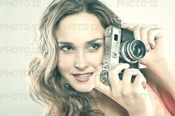 Smiling Caucasian woman holding camera