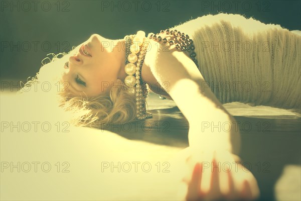 Caucasian woman laying on sunny floor