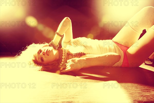 Caucasian woman laying on sunny floor