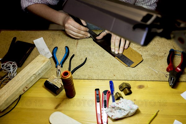 Hands of Caucasian man using ruler in workshop