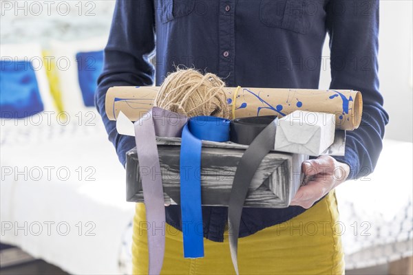 Midsection of Caucasian woman holding box and ribbons