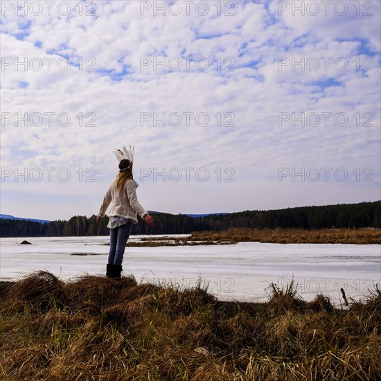 Caucasian woman wearing headdress near river