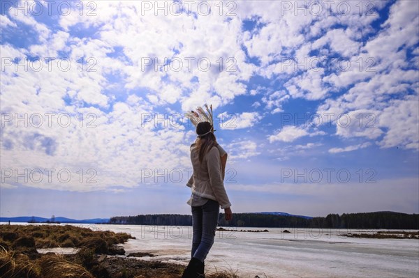 Caucasian woman wearing headdress near river