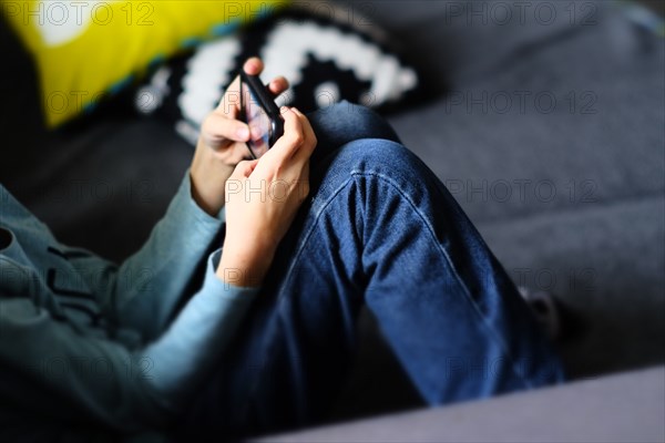 Close up of Caucasian boy playing with cell phone