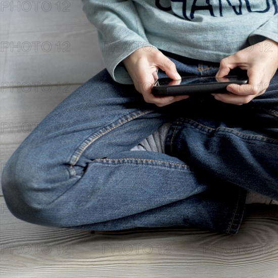 Close up of Caucasian boy playing with cell phone