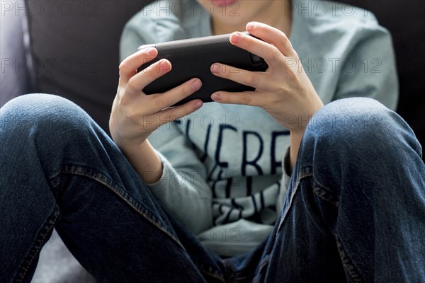 Close up of Caucasian boy playing with cell phone