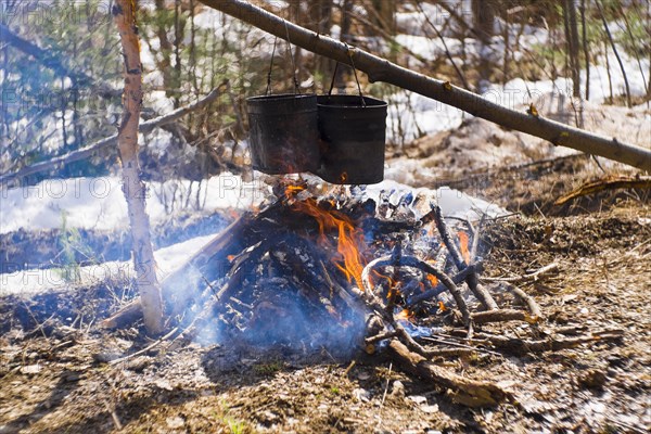 Food cooking in pots over a campfire