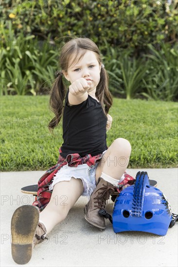 Caucasian girl sitting on skateboard