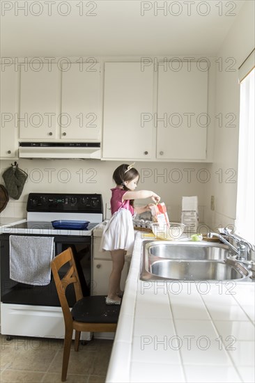 Caucasian girl baking in kitchen