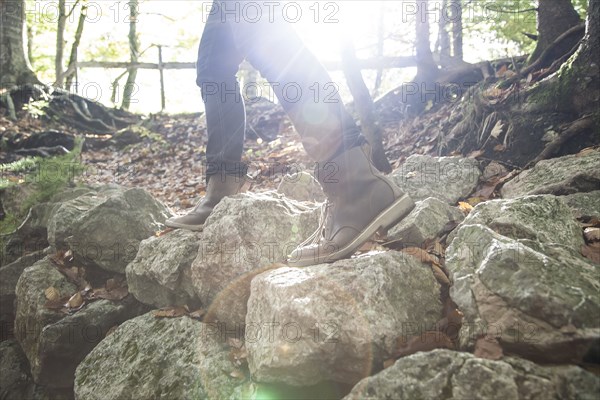 Legs of Caucasian man walking on rocks