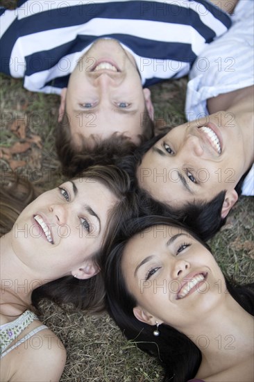 Friends laying in formation in grass