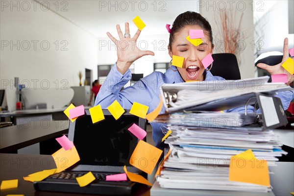 Hispanic businesswoman covered in sticky notes