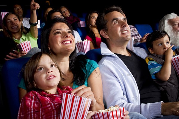 Hispanic family watching film in movie theater