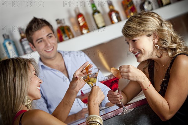 Hispanic friends drinking cocktails in bar