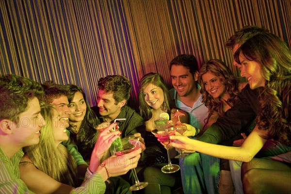 Hispanic friends drinking cocktails in bar