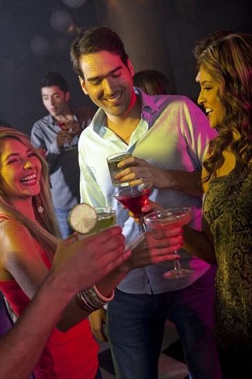 Hispanic friends drinking cocktails in bar