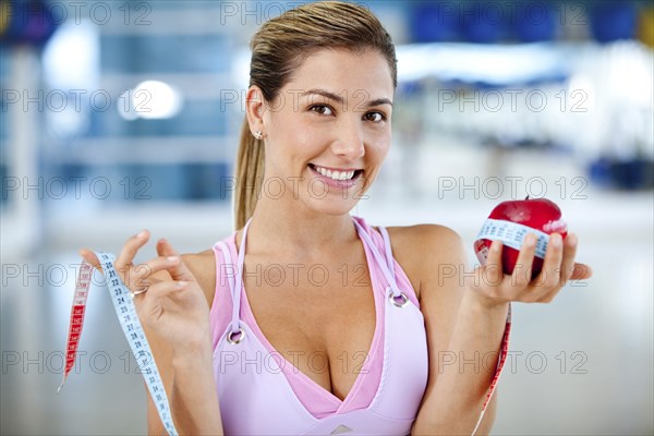 Hispanic woman measuring apple