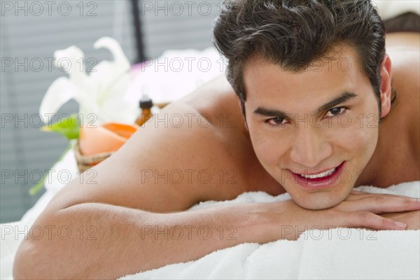 Hispanic man laying on massage table