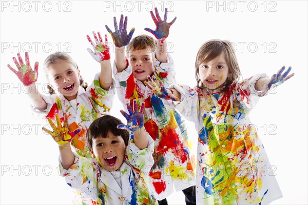 Messy Hispanic children finger painting