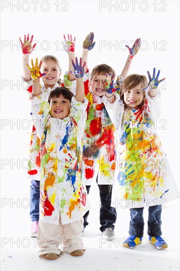 Messy Hispanic children finger painting