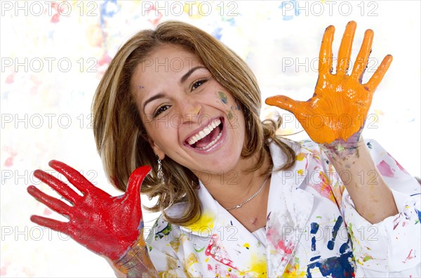 Messy Hispanic woman finger painting