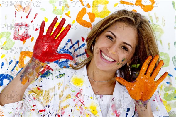 Messy Hispanic woman finger painting