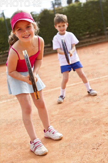 Hispanic children playing double's tennis