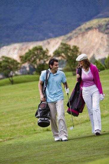 Hispanic couple playing golf together