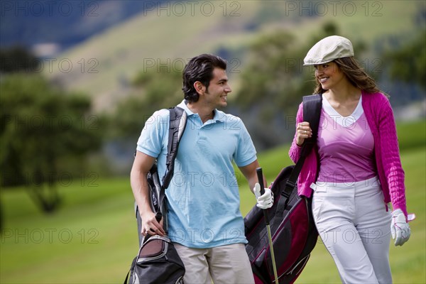 Hispanic couple playing golf together