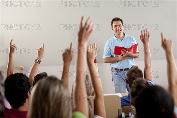Hispanic college students raising arms in classroom
