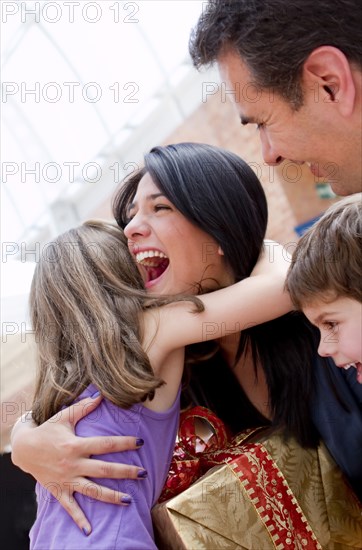 Hispanic girl giving excited mother birthday gift