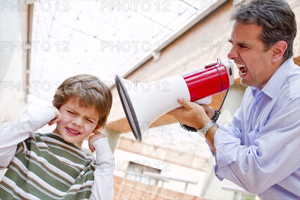 Hispanic father shouting at son through bullhorn