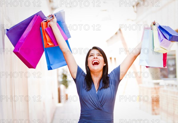 Hispanic woman lifting shopping bags