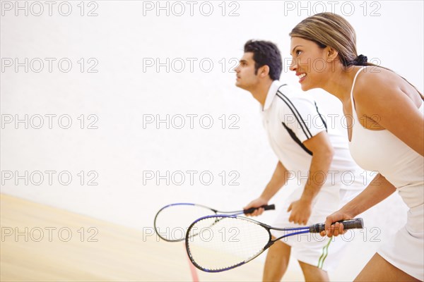 Hispanic couple playing squash