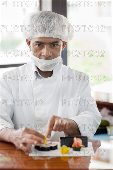 Hispanic chef preparing sushi in restaurant