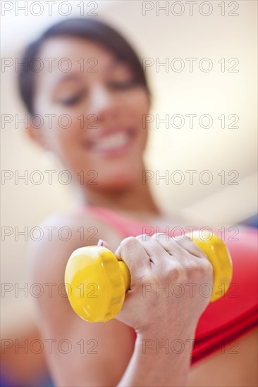 Woman lifting weights in gym