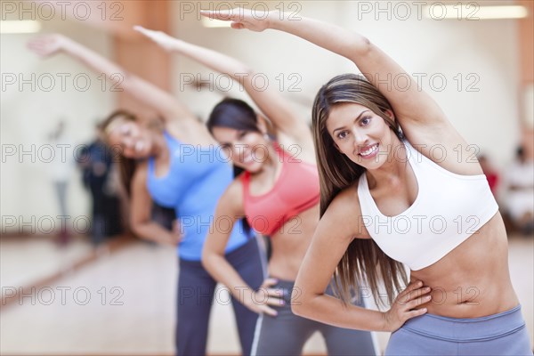 Hispanic women taking exercise class in gym