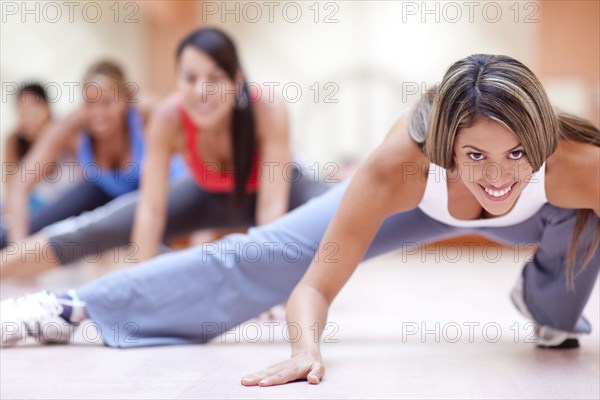Hispanic women taking exercise class in gym