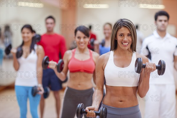 Hispanic people taking exercise class in gym