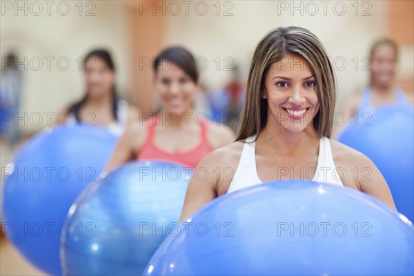 Hispanic women using exercise balls in gym