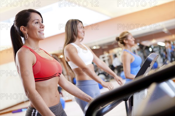 Hispanic women using treadmills in gym